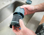 A person holds an opened Epic Water Filters USA Nano XP Replacement Filter over a kitchen sink, displaying the interior filter element with visible dark ridges.