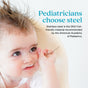 A baby with blue eyes holds an Ahimsa Baby Starter Spoon to their ear. Text: “Pediatricians recommend non-toxic baby utensils. Ahimsa's stainless steel Baby Starter Spoons are the ONLY kid-friendly choice by the American Academy of Pediatrics.”.