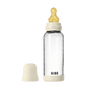 The BIBS Glass Baby Bottle with Natural Rubber Nipple Complete Set (0+ Months) features a clear bottle, cream cap and base, heart-shaped yellow nipple, and BIBS branding. The anti-colic cap is shown beside it on a white background.