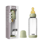 A BIBS Glass Baby Bottle with Natural Rubber Nipple Complete Set - 0+ Months, featuring a light green cap and yellow nipple, stands beside its branded packaging and an extra green cap displayed in front.