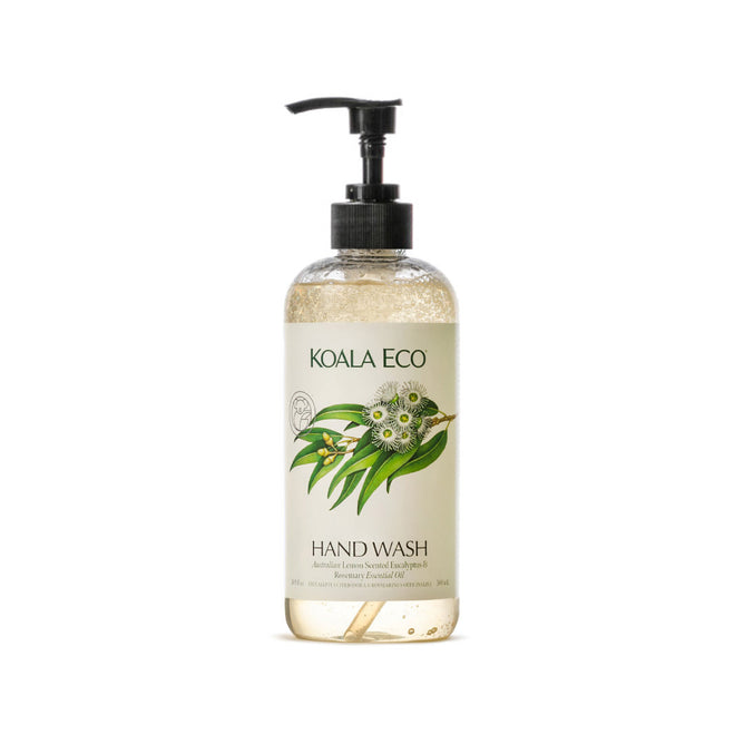A clear pump bottle of Koala Eco Natural Hand Wash features a botanical label with eucalyptus leaves and flowers. It contains light amber liquid soap, scented with lemon-scented eucalyptus.