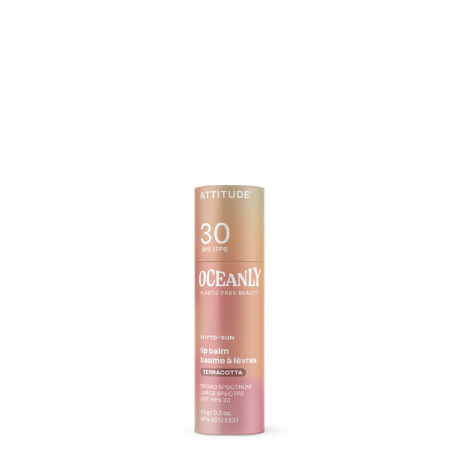 A cylindrical tube of ATTITUDE Oceanly PHYTO-SUN Lip Balm SPF30 with mineral sunscreen stands upright against a white background. The beige, pink, and gold gradient tube displays product details in white text.