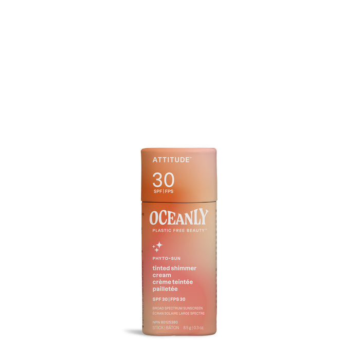 A peach and beige cylindrical tube of ATTITUDE Oceanly PHYTO-SUN Tinted, Shimmer Face Sunscreen Cream SPF 30 stands upright against a white background. The vegan formula contains mineral shimmer and is labeled in white text.