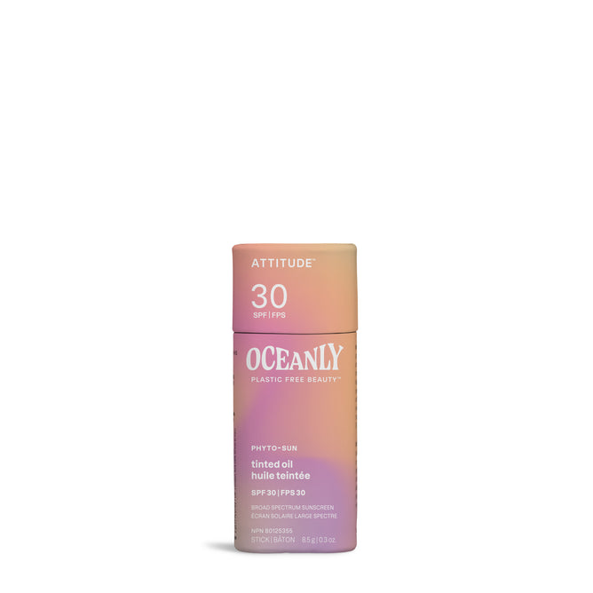 A tube of Oceanly PHYTO-SUN Tinted Face Sunscreen Oil SPF 30 by ATTITUDE, featuring non-nano zinc oxide and a gradient pink, orange, and yellow design with white text, stands upright on a white background.