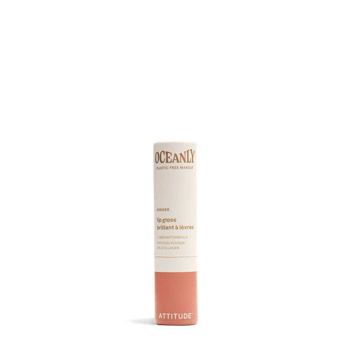 A tube of ATTITUDE Oceanly Lip Gloss with a beige and coral design, gold and pink printed details, stands upright on a white background.