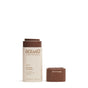 Oceanly Bronzer by ATTITUDE in the shade Ebony stands upright with its brown cap nearby on a white background, providing a natural-looking color for a radiant, glowing finish.