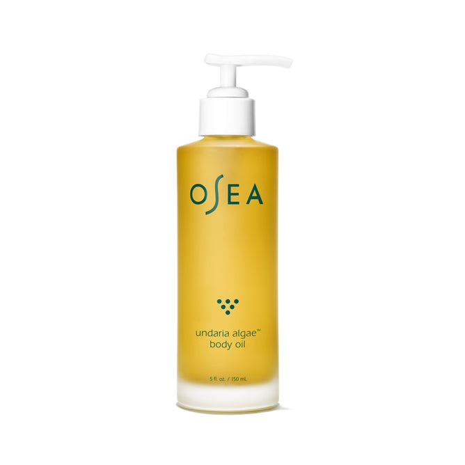 A clear bottle of OSEA Undaria Algae® Body Oil with a white pump and teal-gold label provides 150 mL (5 fl. oz) of nourishing oil for deep moisturization and improved skin elasticity.