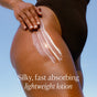 A close-up of a person in a dark swimsuit applying Undaria Algae™ Body Lotion by OSEA to their thigh, with text overlaid: 