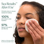 A woman gently wipes her face with a cotton pad. Text highlights that 100% saw a boost in skin hydration and 97% agreed OSEA Ocean Wave Cleanser Bi-Phase Cleansing Oil and Makeup Remover was gentle yet effective—even on waterproof makeup.