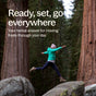 A person in a green jacket and pink hat leaps between rocks in a forest, with text: Move freely every day with New Chapter Drug-Free Pain Relief Capsules - for Aches, Soreness & Discomfort.