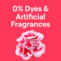 A cluster of pink and white flowers pops from a bright red backdrop, while bold white letters announce 0% Dyes & Artificial Fragrances, highlighting the hypoallergenic qualities of Seventh Generations Concentrated Laundry Detergent.