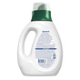 A white plastic bottle of Seventh Generation Liquid Laundry Detergent with a green cap is shown from the back. The label highlights its 2x Concentrate formula, features symbols and a barcode, and the handle is on the left side.