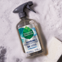 A bottle of Seventh Generation Foaming Dish Spray, featuring a gray nozzle and green-blue label, rests on a soapy surface beside a white sponge—ready to tackle grease for cleaner, sparkling dishes.