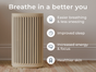 The Windmill Air Purifier by Windmill Air sits on a wooden floor against a wall; accompanying text highlights benefits such as easier breathing, better sleep, more energy and focus, and healthier skin—all thanks to advanced HEPA purification for cleaner indoor air.