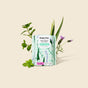 A package of HoneyPot Menstrual Pads - Herbal-Infused 100% Organic Cotton Cover is surrounded by fresh green mint, aloe vera, and lavender on a beige background.