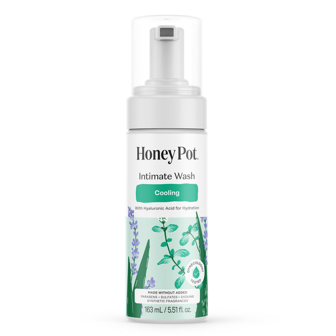 A white bottle of HoneyPot Cooling Intimate Wash - Herbal Infusion with a pump top, featuring images of lavender and mint, and labeled as a pH-balanced intimate cleanser made with hyaluronic acid. This cooling intimate wash leaves you feeling fresh and comfortable.