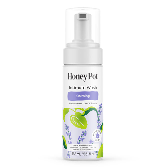 A white bottle of HoneyPot Calming Intimate Wash - Herbal Infusion with a clear pump features lavender illustrations and green leaves. The label emphasizes its calming formula and sensitive, fragrance-free design, making it the perfect soothing herbal wash for gentle intimate skin care.