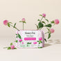 A package of HoneyPot Peri-menopause Long Liners - Harmonizing Herbal Infusion, featuring organic cotton covers and herbal-infused pads designed to support hormone balance, is surrounded by fresh clover flowers and leaves on a neutral beige background.