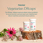 Two bottles of True Grace One Daily Women's Probiotic sit on a wooden platform with flowers. Text above highlights Patented Vegetarian DRcaps® for delayed release, enhanced potency, and digestive health support.