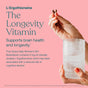 A hand holds two brown capsules above a glass of water on a pink background. True Grace Daily Women’s 50+ Multivitamin Tablets offer longevity and memory support, specially designed for women aged 50+.