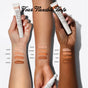 Three arms with varying skin tones display swatches of four lightweight ReFresh Eye Brightener SPF 30 shades—Adore, Cherish, Hush, Swoon—next to matching RMS Beauty tubes. The text above reads Four Flexible Tints.