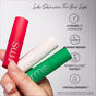 A hand holds RMS Beauty’s The Mini Lip Oil Trio in festive red, white, and green tubes. This holiday-ready set delivers 8-hour hydration, repairs the lip barrier, is dermatologically tested, and hypoallergenic.