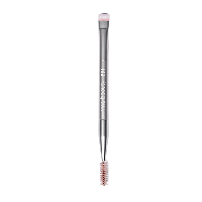 Back2Brow Brush by RMS Beauty is a dual-ended eyebrow tool featuring a round, soft bristle brush for natural brow shaping on one end and a spoolie on the other. The silver handle bears the label “BB1 mine beauty.”.