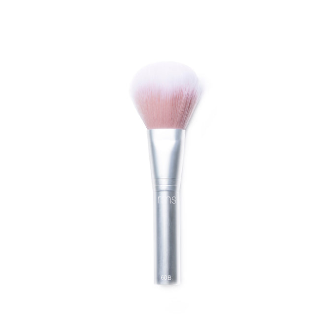 The RMS Beauty Skin2Skin Powder Blush Brush features a silver handle and soft white-to-pink bristles, creating a natural, airbrushed finish—shown against a white background.