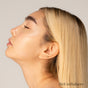 A woman with smooth, glowing skin and straight blonde hair tilts her face upward, eyes closed, showcasing her radiant complexion. In the lower right corner, Rich in Radiance highlights Master Radiance Base by RMS Beauty with Organic Jojoba.