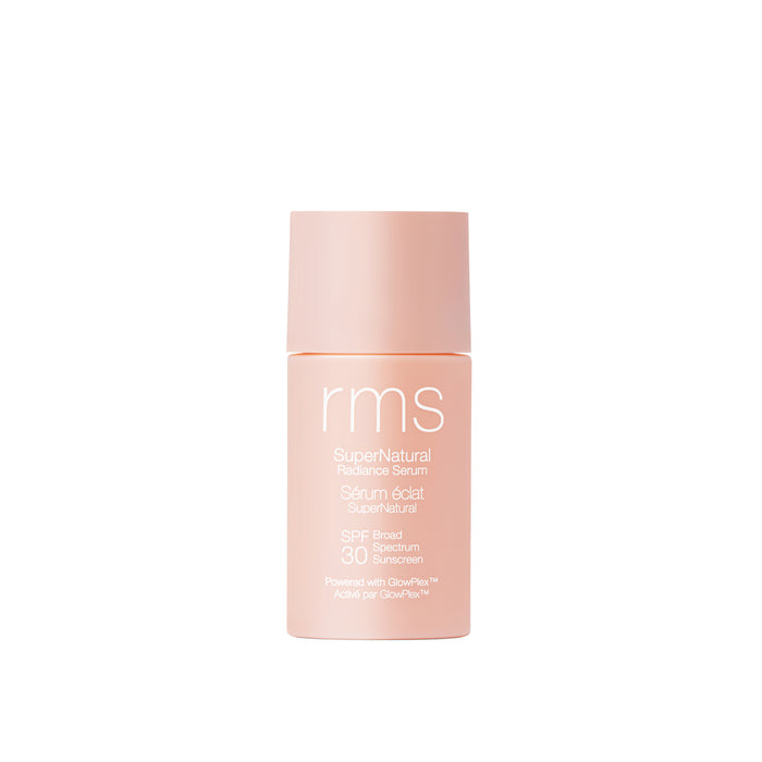 A peach bottle of RMS Beauty SuperNatural Radiance Serum Broad Spectrum SPF 30 Sunscreen with a matching cap stands upright on a white background. Its label displays white text detailing the product.