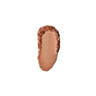 A single swatch of RMS Beauty Hydra Setting Powder in medium brown is smeared on a white background, featuring rough, textured edges and a smooth, even center.