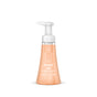 A clear plastic bottle of method Foaming Hand Soap with a sandalwood and cedar scent, enriched with Vitamin E. The light orange liquid soap comes topped with a white pump dispenser.