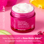 Open jar of Andalou Naturals 1000 Roses Fortifying Night Cream with a rose-biotic blend, housed in a pink glass container featuring Alpine Rose Stem Cells.