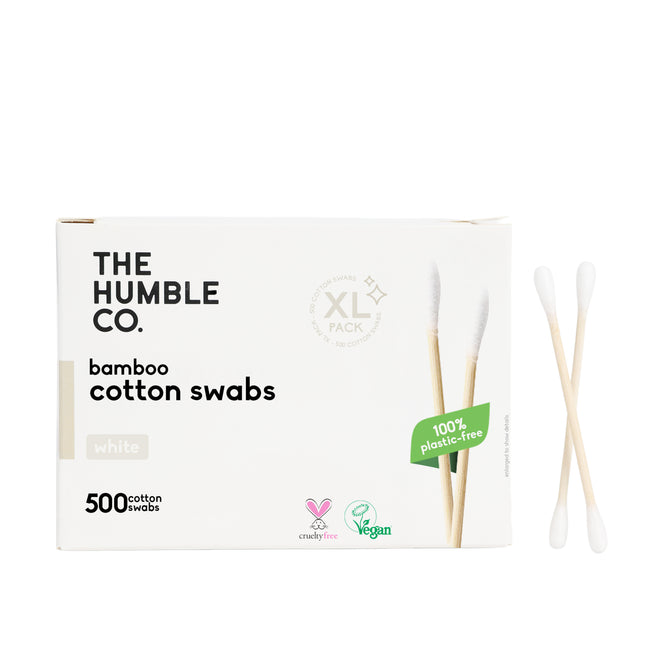 A box labeled The Humble Co. Cotton Swabs - White with two bamboo swabs beside it. The 500-count box is 100% plastic-free and displays cruelty-free and vegan logos.