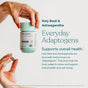 A woman pours a capsule from a True Grace One Daily Women's Multivitamin bottle, featuring Holy Basil, Ashwagandha, and organic mushrooms for immune, energy, balance, and beauty support.