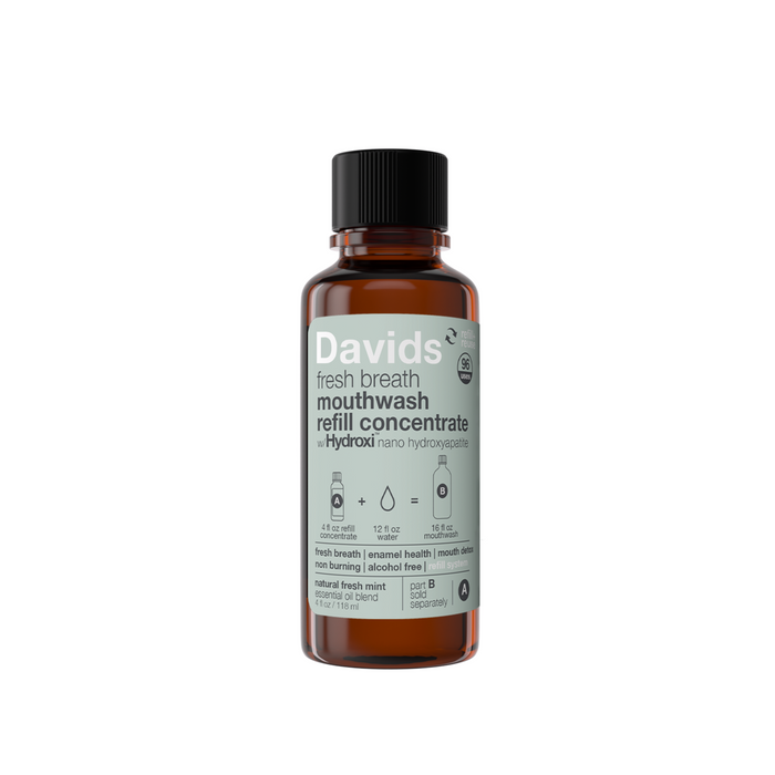 A brown bottle labeled Davids Hydroxi Fresh Breath Mouthwash Refill Concentrate with nano-Hydroxyapatite highlights enamel health, fresh breath, non-burning, alcohol-free, and mint flavor.
