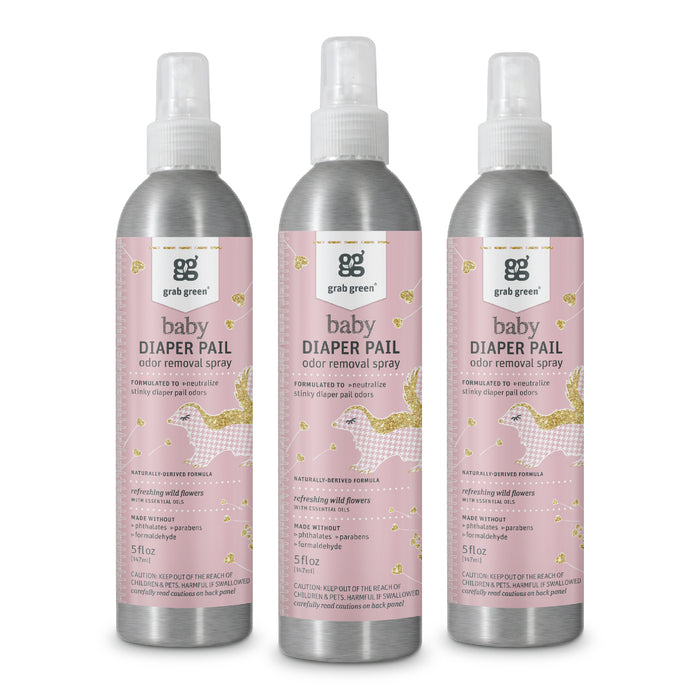 Three bottles of grab green Baby Diaper Pail Odor Removal Spray - Wild Flowers are displayed. They have a pink label with golden leaves and a baby carriage, labeled natural & fragrance-free. Each 5 fl oz bottle contains Zinc ricinoleate for effective odor control.