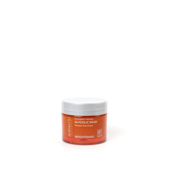A small orange jar of Andalou Naturals Brightening Pumpkin Honey Glycolic Mask with a white lid, featuring pumpkin enzyme and glycolic acid, is centered on a white background.