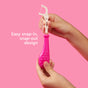 Two hands hold a pink Radius Kids EcoFlex™ Refill Bag compostable floss pick handle with a detachable white floss head. Text reads: Easy snap-in, snap-out design. The solid pink background highlights this eco-friendly solution from Radius.