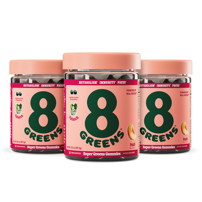 Three containers of 8Greens Super Greens Gummies - Peach (Multi-Packs) are displayed, each with a pink label that highlights benefits like boosting immunity, supporting metabolism, and enhancing focus. The packaging features green text and peach slices to emphasize the gummies health benefits.