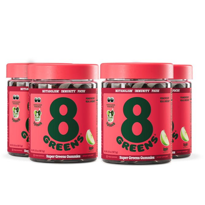 Four jars of 8Greens Super Greens Gummies - Apple (Multi-Packs) feature red labels with lime wedge images, highlighting metabolism support, immunity boost, and focus benefits. The delicious apple flavor ensures a tasty and effective way to maintain health.