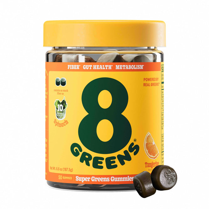 A jar of 8Greens Super Greens Gummies - Fiber in tangerine flavor features a bright yellow label with green text, promoting benefits like improved metabolism and gut health. Two gummies placed in front of the jar are ready to elevate your wellness journey.