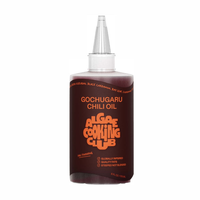 A plastic squeeze bottle of ALGEE ANIME COOKING CLUB Gochugaru Chili Oil with an orange label and pointed nozzle cap. The label lists ingredients and product details in bold, modern fonts.