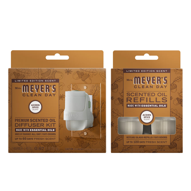 Two Mrs. Meyer’s Fall Diffuser Kit Collection products: a Fall Diffuser Kit (Acorn Spice scent) on the left and a matching Acorn Spice refill pack with two visible refills in an orange-brown box on the right.