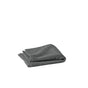 A neatly folded dark gray Coyuchi Air Weight® Organic Towel sits on a plain white surface, centered in the image.