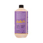 The back of an Alaffia EveryDay Shea Bubble Bath bottle with a purple label displays product details, icons for fair trade shea butter and lavender oil, and sustainability information. The bottle features a black cap, and inside is a light orange, gentle sulfate-free bubble bath.