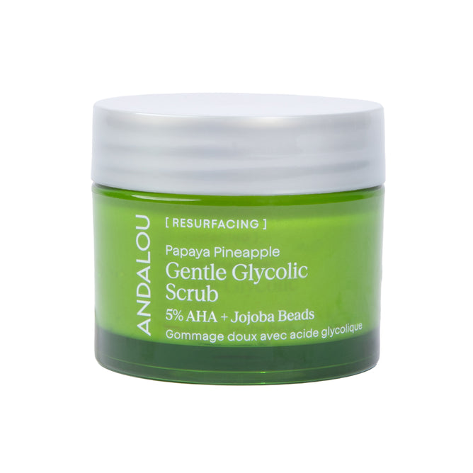 A green jar of Andalou Naturals Resurfacing Gentle Glycolic Scrub with a white lid, featuring product details and 5% AHA + Jojoba Beads on the label. This exfoliating scrub blends glycolic acid with natural fruit enzymes to reveal smoother, more radiant skin.
