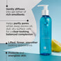 A blue bottle of Andalou Naturals Clear Skin Citrus Kombucha Cleansing Gel with a white pump stands upright beside a sliced lemon, with text on a blue background highlighting its benefits for blemish-prone skin.