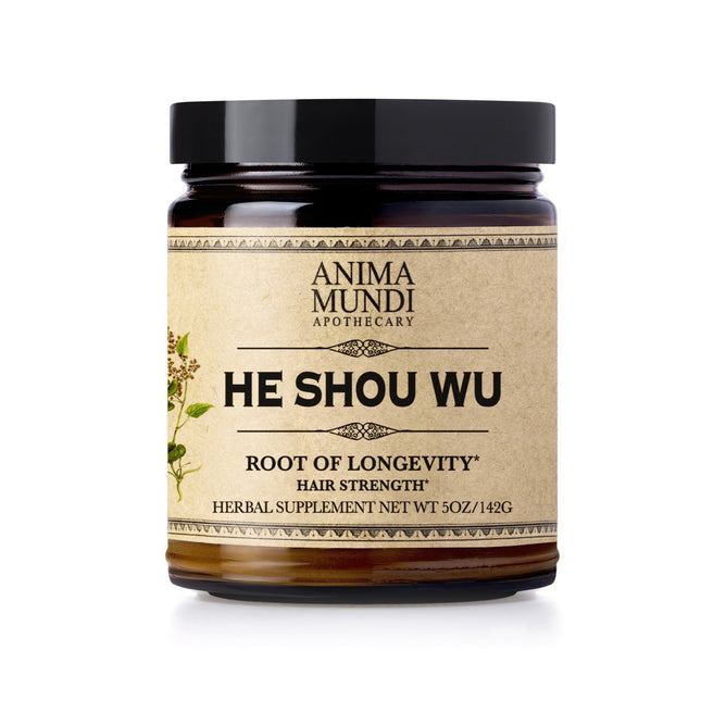 A dark glass jar labeled Anima Mundi HE SHOU WU, Hair Strength, features a beige label with botanical art; this herbal supplement is inspired by Traditional Chinese Medicine to support hair vitality. Net Wt 5oz/142g.