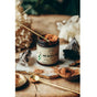 An open jar of Anima Mundi HE SHOU WU, Hair Strength sits on a wooden surface, surrounded by powders, crystal stones, a gold spoon and a brass spoon, with a gold scoop inside the jar.